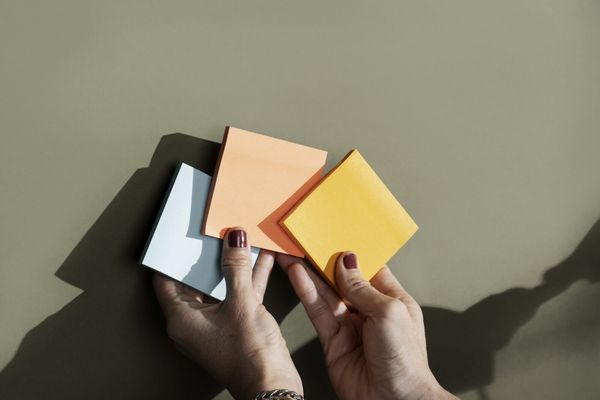 top-view-hands-holding-colorful-post-its